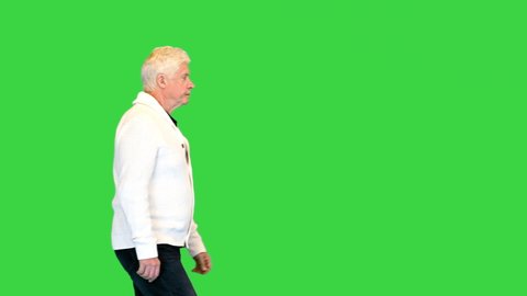Senior man walking and looking forward on a Green Screen, Chroma Key.