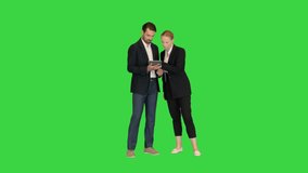 Beautiful young business woman and handsome businessman in formal suits are using a digital tablet on a Green Screen, Chroma Key. - Powered by Shutterstock - Get 15% off with code: PIKWIZARD15
