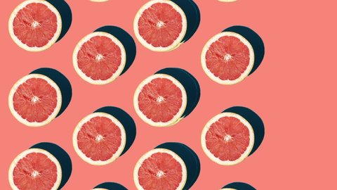 Halves of grapefruit moving from the left side on the pink surface Video Stok