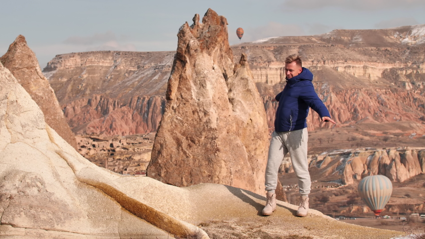 A young guy is enjoying the mountains in Cappadocia. Turkey.