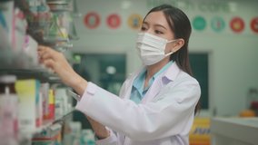 An asian woman pharmacist wearing lab coat and protective mask  using tablet to analytics medical data  in a modern pharmacy drugstore - Powered by Shutterstock - Get 15% off with code: PIKWIZARD15