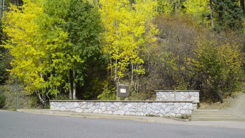 Short stone wall with Treasure Falls sign. In Pagosa Springs, Colorado, U.S.