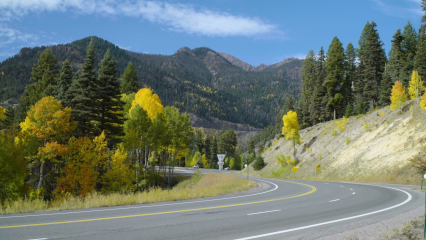 Curve on the road among forest with mountain range in the background. Clips of US 160 heading to Treasure Falls Colorado and two of Treasure Falls signs and area. In Pagosa Springs, Colorado, U.S.