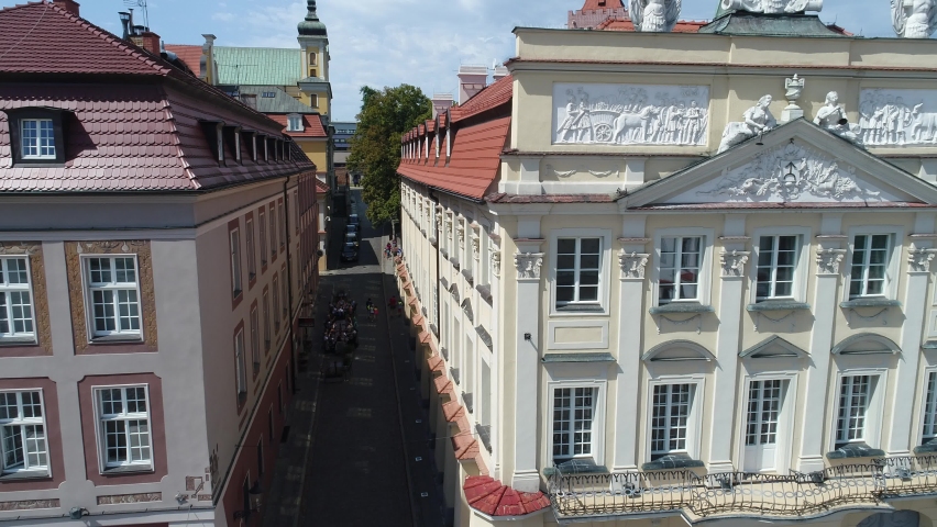 An atmospheric, historic, cobbled street leading out of the old market square in Poznań.