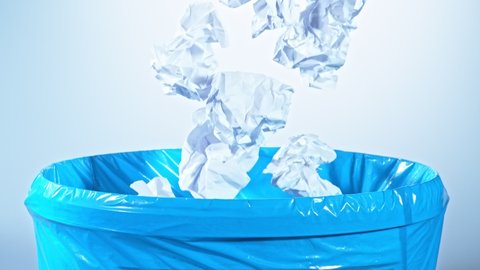 Super Slow Motion Shot of Crumpled Papers Falling into Trash Can at 1000fps.