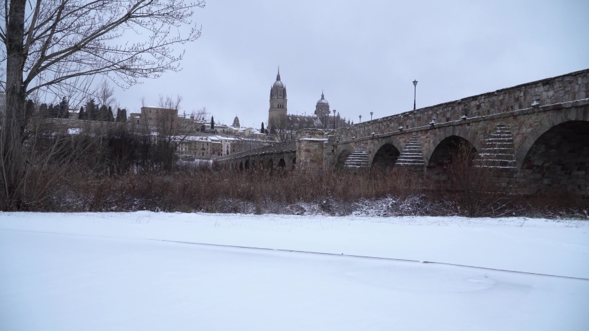 Snow in Salamanca city, Spain. Old cathedral and Roman bridge view