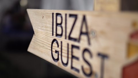 Ibiza guest wooden sign at night.