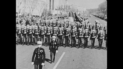 1950s: Navy men in uniform march down street with flag. The exterior of the Smithsonian. Spirit of St. Louis airplane exhibit, people walk around museum. Aerial view of the Potomac. Buildings.
