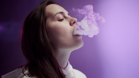 Young Woman Female Smoker Smoking E-Cigarette in studio.
