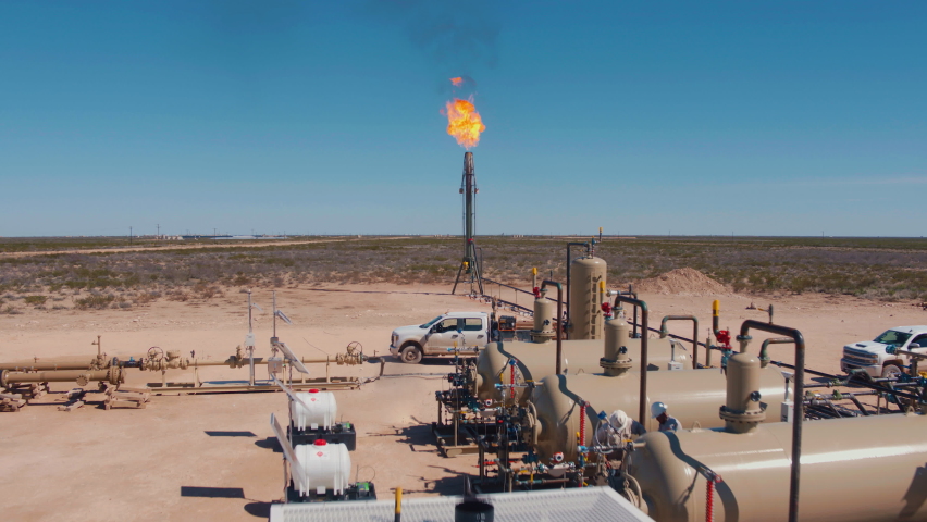 Out on the Permian Basin the pressure relief valve is relieving pressure at an over pressured gas processing facility through the process of flaring.  | Shutterstock HD Video #1068073436