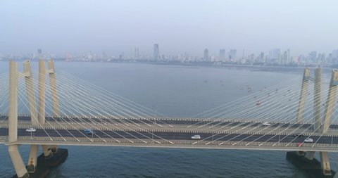 Flying over the iconic Bandra Worli Sea link bridge in Mumbai revealing the city view in the back.