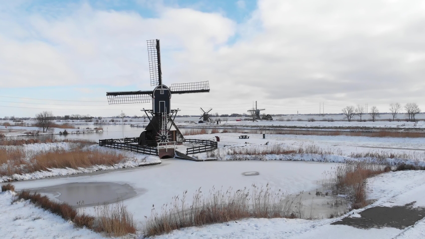 Aerial: Netherlands windmills and frozen canals in winter snow
