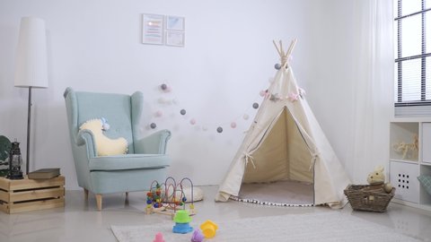 cute play tent. toys and single sofa in children’s game room with white wall background and nobody on a sunny day.