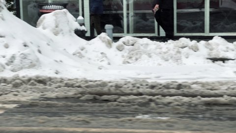 NYC, USA - FEB 18, 2021: driving past piles of snow in winter on 6th ave in Manhattan New York City.