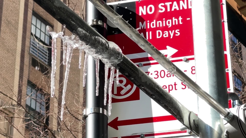 icicles under no standing alternate side parking sign in cold winter in New York City NYC