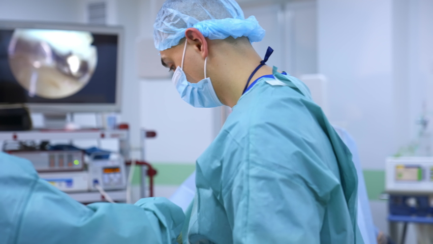 Doctors working with surgical instruments. Doctor performing surgery on patient in operation room with instruments for laparoscopy Royalty-Free Stock Footage #1068085652