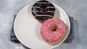 Donuts in the glaze on the plate. The man takes a doughnut and puts it on a plate. - Powered by Shutterstock - Get 15% off with code: PIKWIZARD15