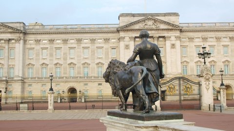 Lockdown in London, slow motion pan of Buckingham Palace with lion statue, during the Coronavirus pandemic 2020.