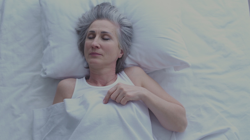 Unhappy tired mature woman awaking early in morning in bad mood, top view Royalty-Free Stock Footage #1068091619