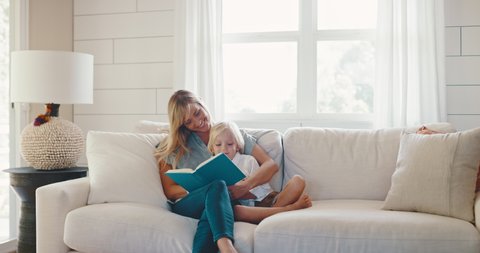 Young mother and son reading together at home on the couch, quality family time, teachable moments, family lifestyle