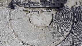Drone video of archeological excavations of the ancient historical amphitheater with a stage and places for spectators. Aerial view Antalya Turkey.