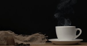 Coffee white cup with natural steam smoke of coffee on black background with copy space, slow motion 4K. Hot Black Coffee Drink Concept. Filmed on high speed cinema camera.