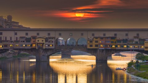 Florence skyline sunset over Ponte Vecchio Florence zoom Timelapse at night and Arno river in Florence Italy City. Reflection on water.