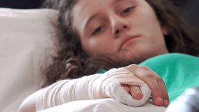 4k Girl massage her broken hand with cast on it. Lying in hospital bed. Close up on plaster, cast, gypsum. UHD stock video