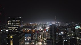 Beautiful aerial panorama of Seoul Gangnam District on the night. Camera moving up high between skyscrapers showing glittering lights of the evening city with modern buildings, streets and traffic.