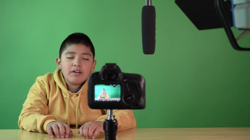 Confident little boy blogger recording a video for his blog