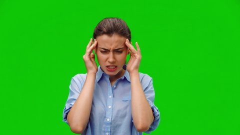 Woman with pain in her temples. American woman in blue shirt suffering from stress or headache grimacing in pain on green background. Medical concept. Alpha channel