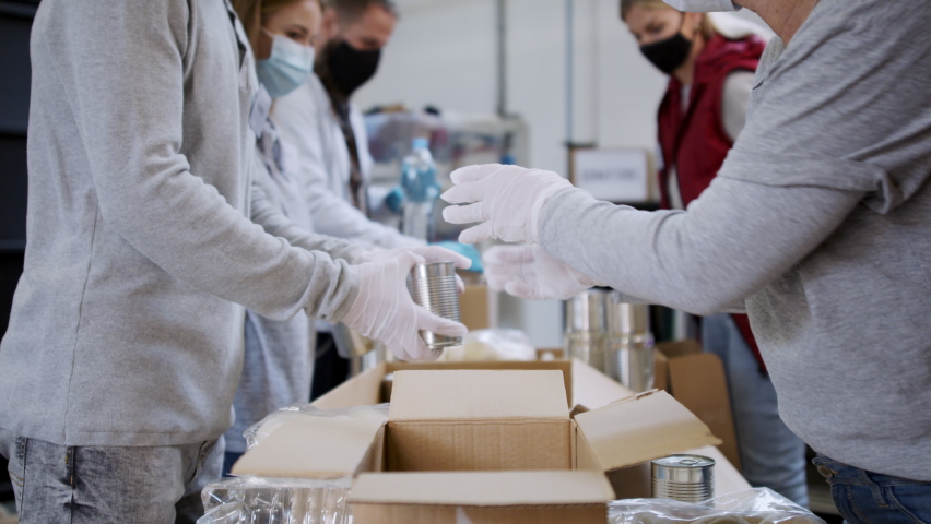 Group of volunteers in community donation center, food bank and coronavirus concept. Royalty-Free Stock Footage #1068117449