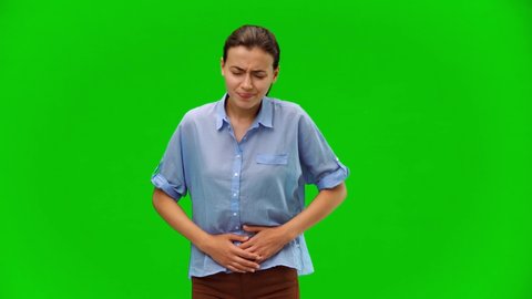 Woman suffering from strong abdominal pain. American woman in blue shirt on green background. Alpha channel