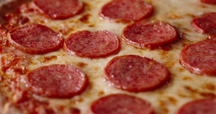 Close up shot of delicious pepperoni pizza with mozzarella cheese straight out of the oven. Tasty Italian pizza - food and drink 4k footage | Shutterstock HD Video #1068130754