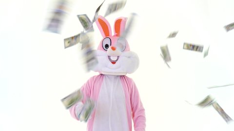 Happy Easter. Rich lucky funny man millionaire businessman holds fan of dollar, throwing dollars, scatters USD banknotes, shows thumb finger up. Money rain, falling dollars isolated. Finance concept