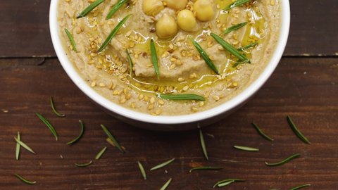 Top view of a bowl with chickpea hummus on a nice wooden background