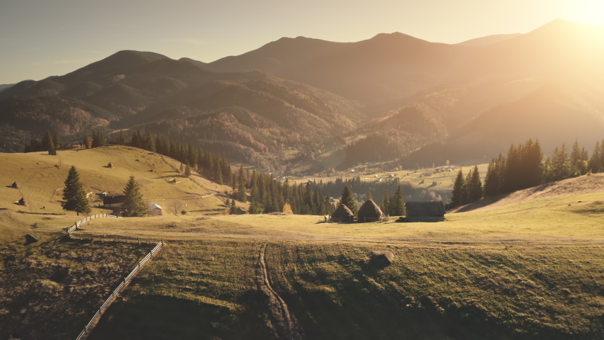 Burnt grass fields at Alps mountain village aerial. Nobody nature landscape. Cottages at countryside farmlands. Mountaineering vacation. Sun spruce forest. Travel to Alpine mounts, Switzerland, Europe Royalty-Free Stock Footage #1068147221