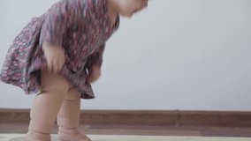 Authentic close up little infant child girl 1 year old in colorful dress sits yawns gets up and tries to go to mom but falls and cries on white background indoors. parenthood, childhood, life concept - Powered by Shutterstock - Get 15% off with code: PIKWIZARD15
