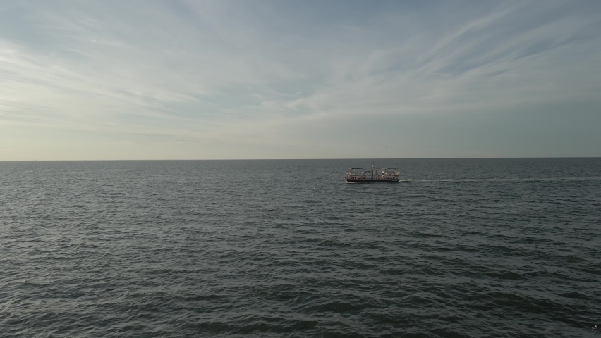 Aerial drone tracking of a pirate ship sailing in the salt waters of the lagoon. Excellent filming in the golden hour of the city.