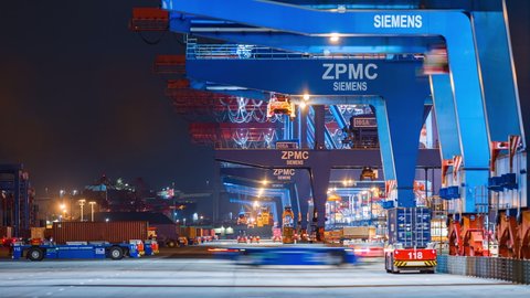 HAMBURG, GERMANY - 02 22 2021: Container ship loading and unloading in deep sea port, Automated transport vehicles Container loading cargo, Time Lapse