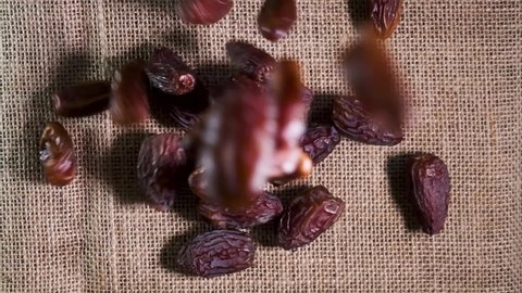 A Heap of Date Fruit on Hessian Cloth Background. Dates Falling to Jute Fabric. Iftar Food Mostly Eating in Ramadan. High Angle View. Slow Motion Shot. B Roll.