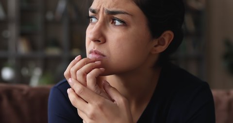 Close up frustrated worried unhappy millennial mixed race indian woman frowning, suffering from negative thoughts or headache, feeling doubtful thinking of difficult decision, depression concept.