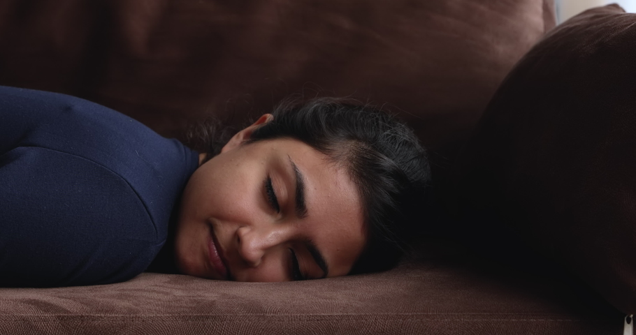 Head shot exhausted young indian ethnicity woman falling down on cozy couch, sleeping resting at home after hard working day, relieving stress or renewing energy at home, relaxation concept. | Shutterstock HD Video #1068156947