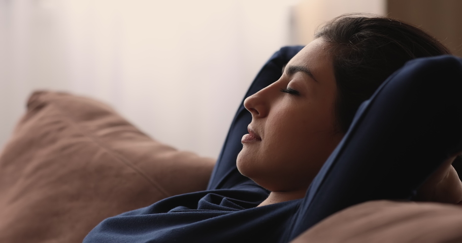 Close up head shot relaxed young indian mixed race woman daydreaming napping sleeping on cozy couch, enjoying peaceful stress free leisure weekend pastime alone in living room, breathing fresh air. Royalty-Free Stock Footage #1068156962