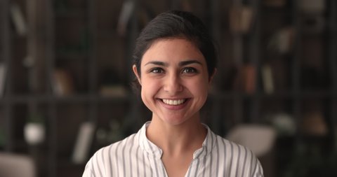 Head shot portrait of smiling beautiful millennial indian mixed race businesswoman looking at camera, showing self confidence, youth multiracial generation female representative, career concept.