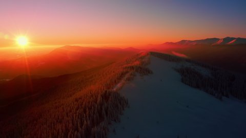 Aerial view of Snowy Mountain Range Silhouette Sunrise Aerial View. Scenic Dawn Sunlight Mountainous. Wild Nature Landscape. Flyover Winter National Park 