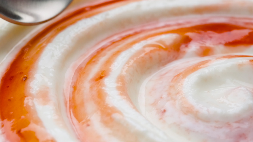 Yogurt with fruit jam in spoon, curd cream swirl with berry topping, extreme close up | Shutterstock HD Video #1068163364