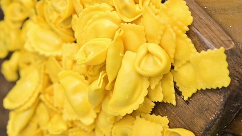 Different Tartollini with cheese or meat for cooking in broth, different shapes. Traditional dish for celebrations in italy, Emilia Romagna region. Fresh homemade pasta. Vertical video,social networks