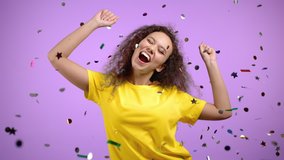 Happy woman dancing, having fun, screaming WOW, rejoices over confetti rain in violet studio. Champion girl. Concept of celebrating, party, winning - Powered by Shutterstock - Get 15% off with code: PIKWIZARD15