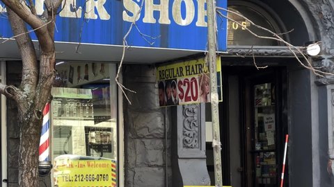 NYC, USA - FEB 25, 2021: barber shop sign with classic spinning pole on Upper West Side Manhattan New York City.